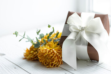 Close up of festive gift box and chrysanthemum flowers.