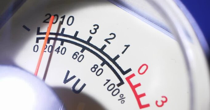 detailed extreme close-up, moving arrow of analog VU meter scale.