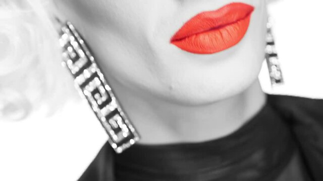 close up black and white face of travesty actor with red lips and catchy makeup.