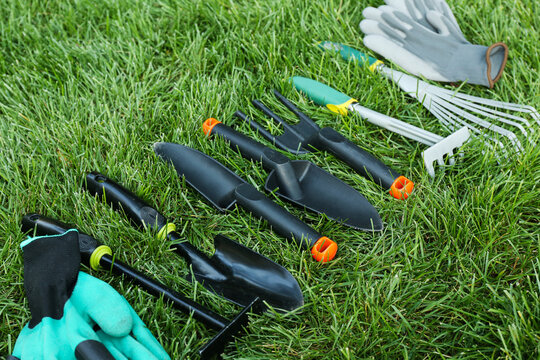 Different gardening tools on green grass outdoors