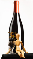 drewniana lalka, winogrona i butelka wina