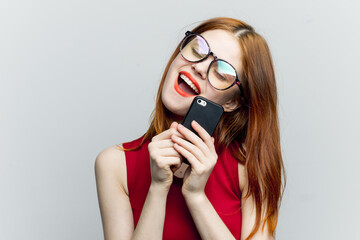 emotional red-haired woman with a phone in her hands communicating gadget
