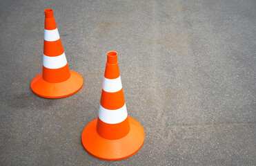 Orange traffic cones on an asphalt road. Background for the text about road news. Passing the car...