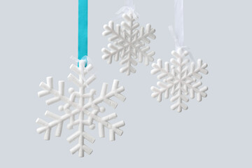 Beautiful Christmas snowflakes hanging on light background