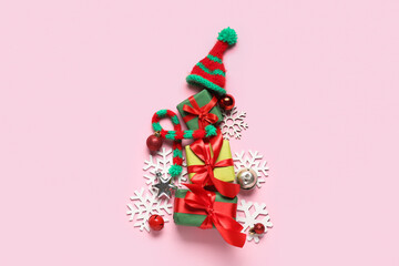 Christmas tree made of decorations and gifts on color background