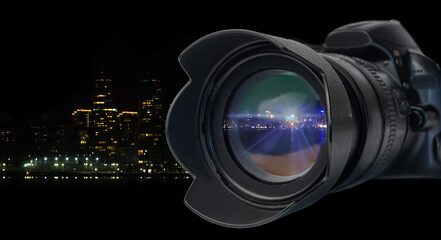 modern DSL camera and telephoto lens with lens hood close up on background of night city lights - obrazy, fototapety, plakaty