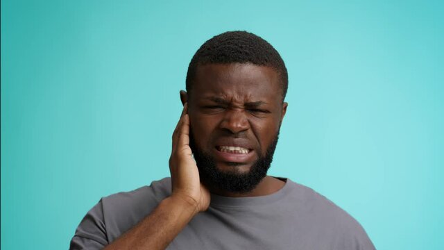 Ear Pain. Unhappy Black Guy Suffering Earache, Touching Sore Area And Frowning