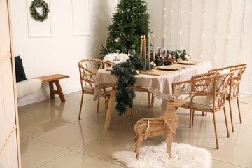 Dining table with beautiful setting for Christmas celebration in festive room