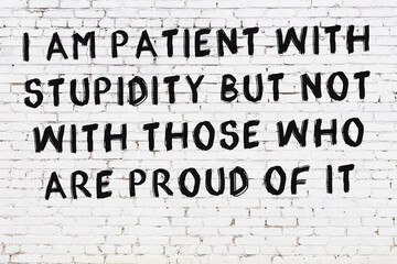 Painted black mindful inscription on white brick wall background