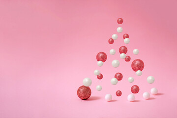 Creative Christmas tree composed of floating white and pink baubles. Winter holidays concept.