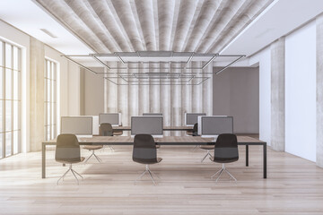 Modern spacious concrete and wooden coworking office interior with window and daylight, table, computer monitors and other items. Law, legal and commercial concept. 3D Rendering.