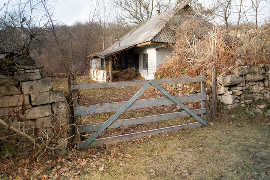 Semi-destroyed stone abandoned buildings in traditional ukrainian style in the village. Old stone adobe house with entrance shed and roof of stone slabs. Ukraine