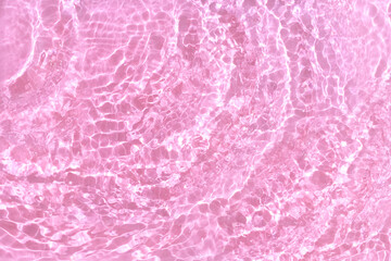 Transparent pink water background. Sun, shadows and ripples. Summer concept. Top view
