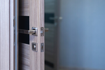 Wooden door with dark glass open, biden lock and metal handle.
