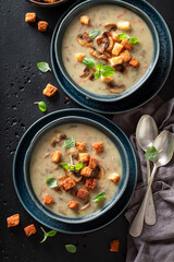 Homemade mushrooms soup with croutons and champignons.
