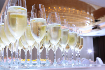Glasses with champagne on the table. Holidays concept. Party in a large bright hall. Secular reception. Buffet at a secular party.Lots of wine glasses. Gala dinner or event.