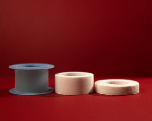 adhesive plasters of different types and colors on a burgundy background in a low key