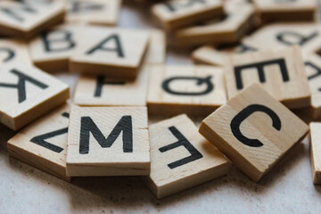 Small wooden letters, scattered on a light background