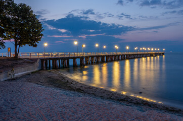 Obraz premium Baltic sea coast, night view of pier at Gdynia Orlowa sea resort, Poland.
