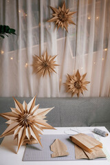 Making of DIY 3D snowflake with brown paper lunch bags, craft Christmas paper decoration, tutorial. Ecological and sustainable celebration. Quick and easy seasonal activity with kids. Vertical shot