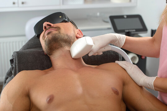 Laser hair removal on mans neck. man in a goggles.