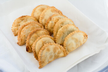 docena de empanadas preparadas para delivery o take away, rellenas horneadas y fritas