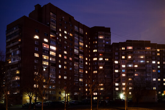 Fototapeta Multi-storey buildings with glowing windows at night