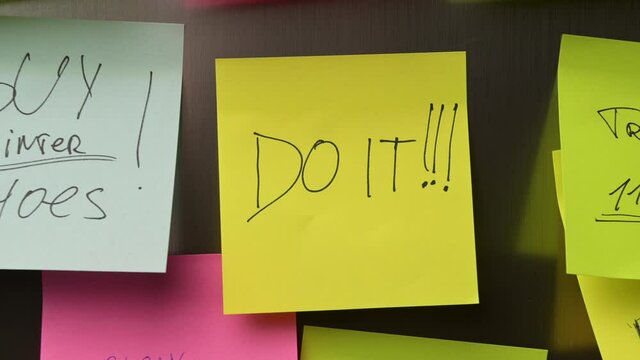 A woman puts a sticker do it on the refrigerator, the camera zooms in and shows a close-up of the main inscription