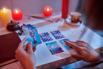 Experienced fortune-teller reading cards laid out on the divination table