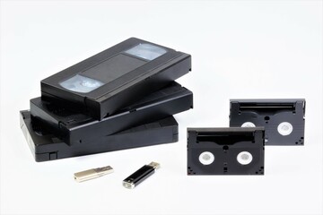 Obraz premium Videotapes and flash drives. The concept of digitizing data from technologically obsolete media to modern ones.
