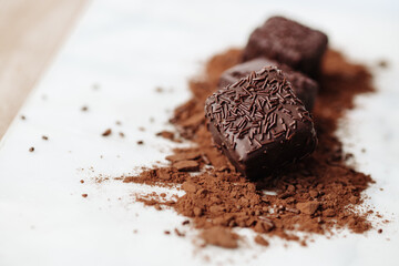 Dark Chocolate Petit Four Cakes on Cocoa and Sprinkles Close Up Valentine's Day Dessert