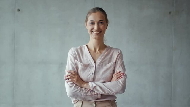 Women and successful career. Positive middle aged business woman in formal wear smiling to camera with crossed hands