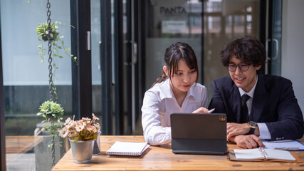 colleagues sitting together at desk in office. Diverse students interns friends looks at pc screen...