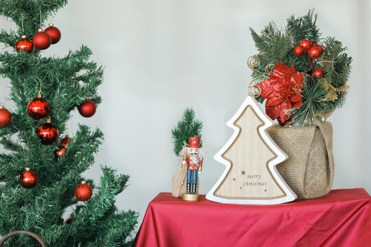 "Merry Christmas" text on wooden tree decoration with Nutcracker doll. Holiday background image.