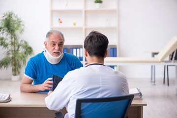 Obraz premium Old male patient visiting young male doctor radiologist