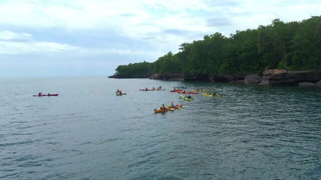 Group of kayakers exploring the apostles island in Lake Superior Wisconsin, Madeline Island during summer. Summer activities visit WI