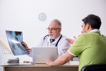 Young man visiting old male doctor radiologist