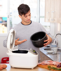 Man cooks lamb dish in electric multicooker. High quality photo
