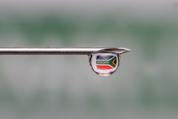 Close up shot of syringe with droplet , see through of South Africa flag with new COVID variant, Omicron text on it.