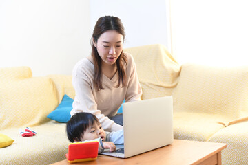 ノートパソコンを操作するお母さんと子供