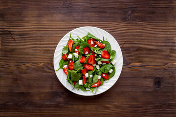 Spinach salad with strawberry and goat cheese, top view