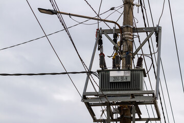 A transformer with concrete poles is used to distribute electric current to several paths, looks confusing cables, the concept of energy and productivity