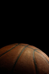 Detail of orange basketball ball with black background. Studio shot with basketball ball isolated.