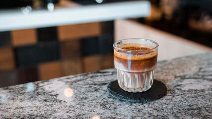 Dirty coffee glass, cold milk topped with hot espresso coffee shot