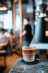 Fototapeta na wymiar Dirty coffee glass, cold milk topped with hot espresso coffee shot