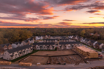 Aerial view of new American neighborhood with townhomes and single family homes during sunset