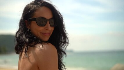 Beautiful, happy woman on the beach wearing sunglasses and smiling for the camera - close up isolated - Powered by Adobe