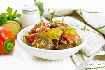 Meat with oranges in bowl on board