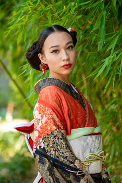 Portrait of woman wearing kimono standing in park