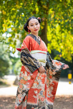 Portrait of smiling woman wearing kimono in park